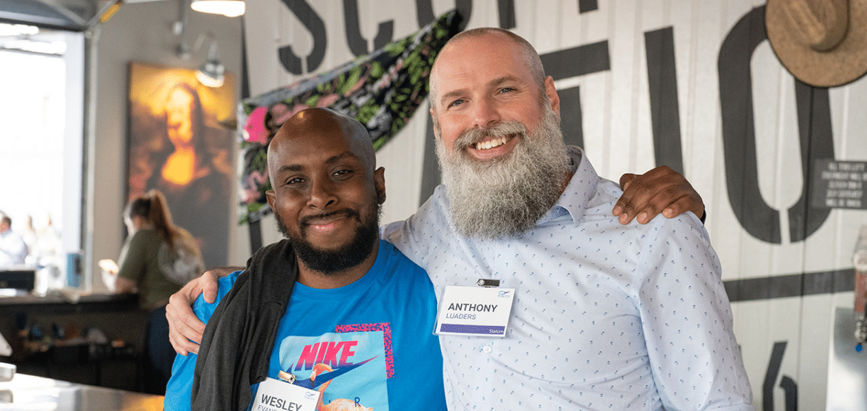two men smiling at work event
