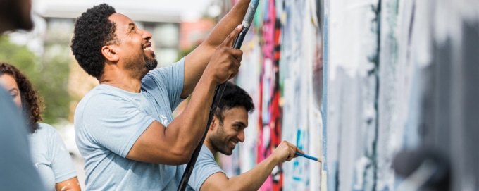 People working together painting a wall in the community