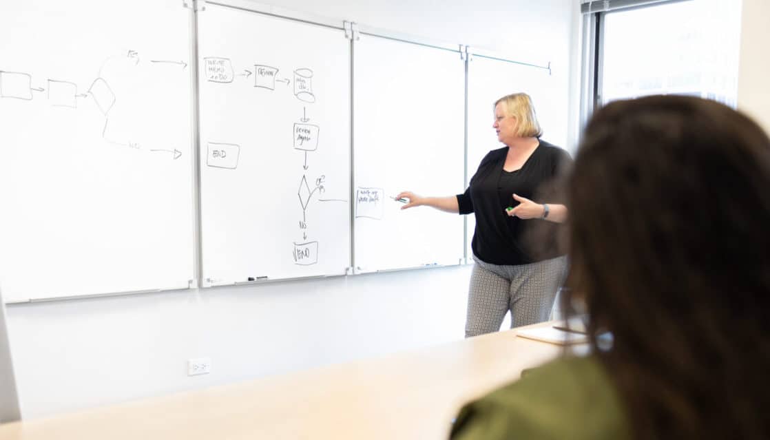 Pariveda leader presenting at a whiteboard in a conference room in the Chicago office