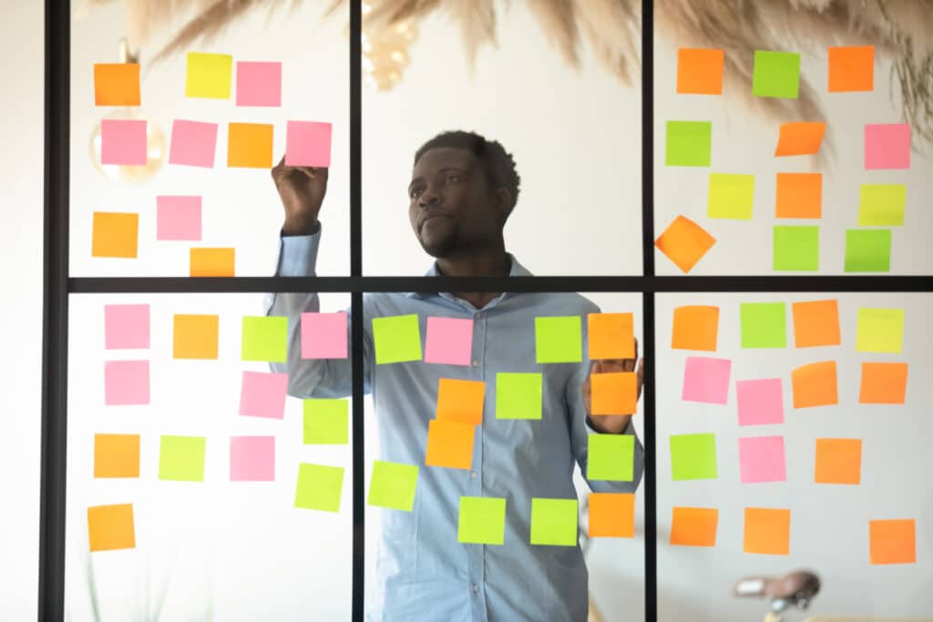 Focused businessman checking project progress on sticky notes