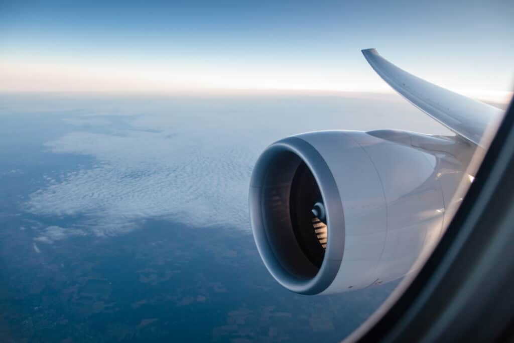 plane passenger window view at sunrise on a large jet while traveling in the sky