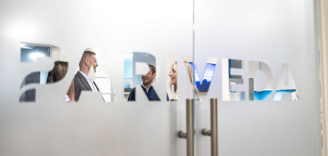 Pariveda employees talking behind glass doors with the Pariveda logo in the Chicago office