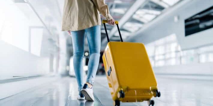 Woman with luggage and walking in airport